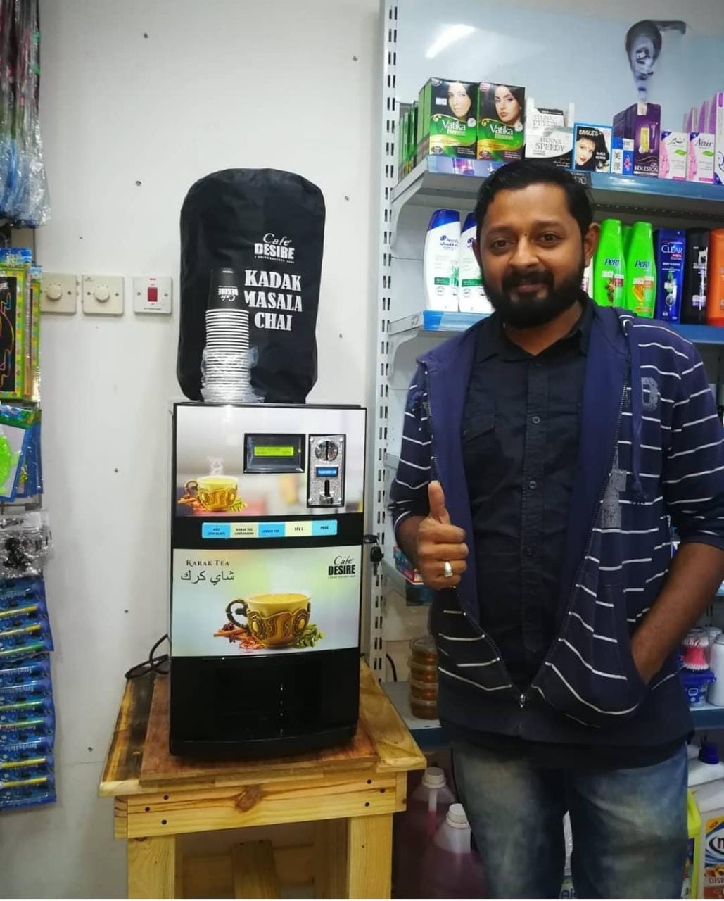 Shopkeeper with Café Desire karak machine at a grocery store